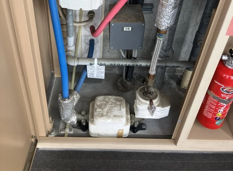 マンションのパイプシャフトの扉を開けたところ。水道メーターと給水管が並んでいる